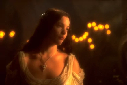 HD PC desktop wallpaper featuring a scene from The Lord of the Rings: The Fellowship of the Ring, showing a softly lit close-up of a female character in a medieval setting.