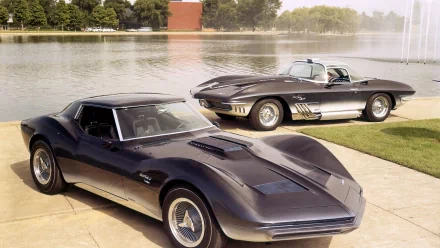 HD desktop wallpaper showcasing two classic Chevrolet vehicles parked near a lake with trees and buildings in the background.