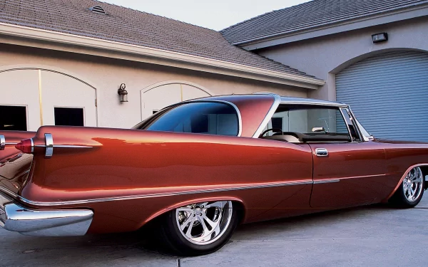 HD PC desktop wallpaper featuring a classic Chrysler vehicle parked in front of a garage, showcasing its sleek vintage design and polished finish.