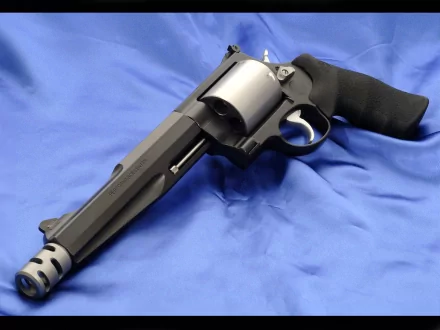 High-definition desktop wallpaper featuring a Smith & Wesson revolver with a black grip resting on a blue fabric background.