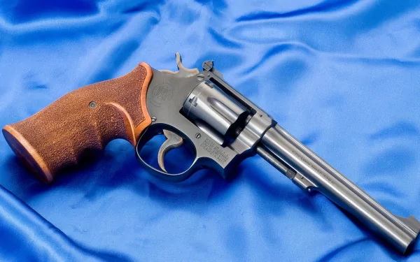 HD PC desktop wallpaper: man-made Smith & Wesson revolver with wooden grip resting on blue satin background.