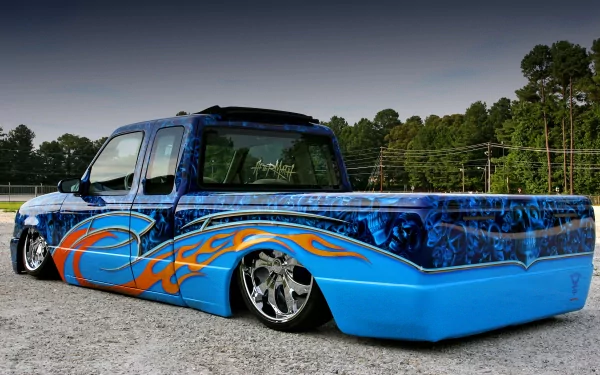 Custom lowered blue truck with flame graphics and chrome wheels, vehicle showcased as a 4K Ultra HD PC desktop wallpaper background.
