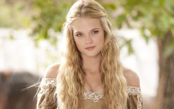 HD PC desktop wallpaper of a long-haired woman in a lace-trimmed period dress, outdoors in soft light, a still from the movie The Three Musketeers.