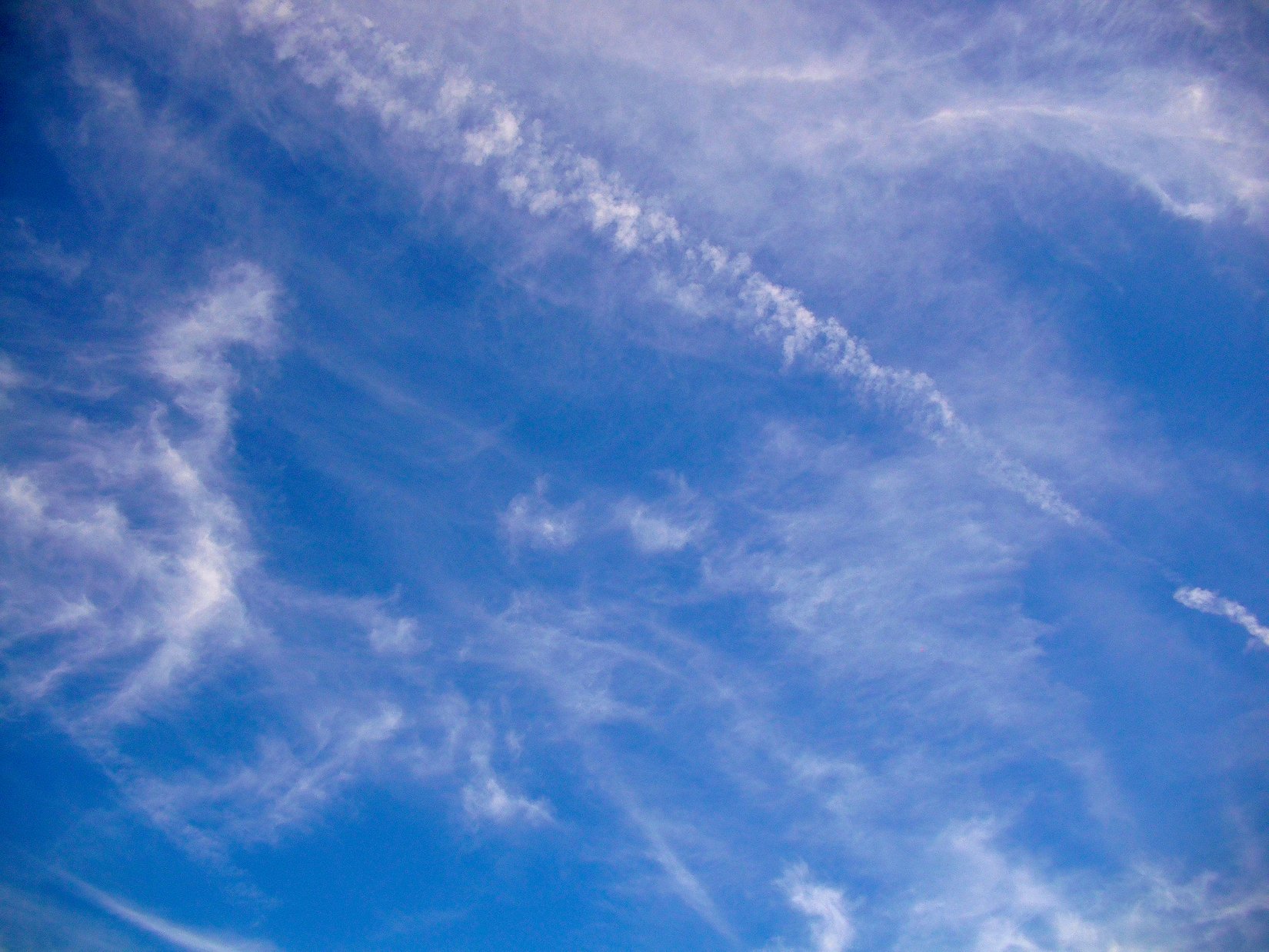 A serene sky filled with wispy clouds, capturing the beauty of nature. This HD wallpaper creates a calming backdrop for any desktop.