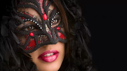 A captivating HD desktop wallpaper featuring a portrait of a woman wearing an ornate black and red mask, set against a dark background, showcasing elegance and intrigue.