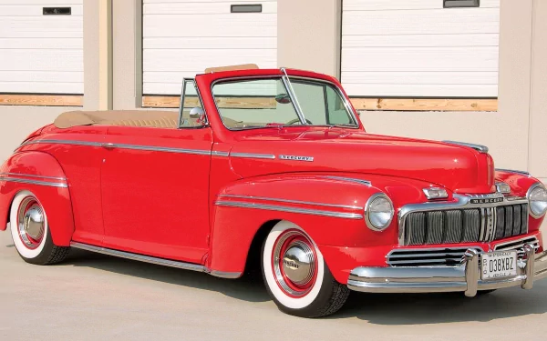 HD desktop wallpaper featuring a classic red Mercury convertible parked outdoors against a light industrial building backdrop.