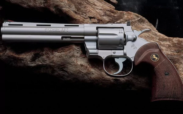 HD PC desktop wallpaper of a man-made Colt Python revolver with wooden grips resting on rugged bark, close-up detail.