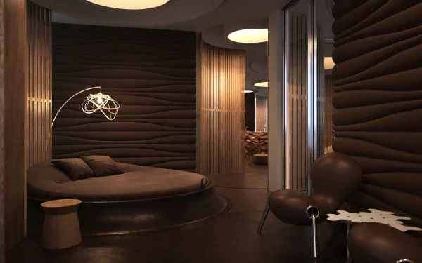 A modern room featuring smooth, curved walls in deep tones, furnished with a circular bed, lounge chair, and a stylish light fixture, creating a cozy, inviting atmosphere for HD wallpapers.