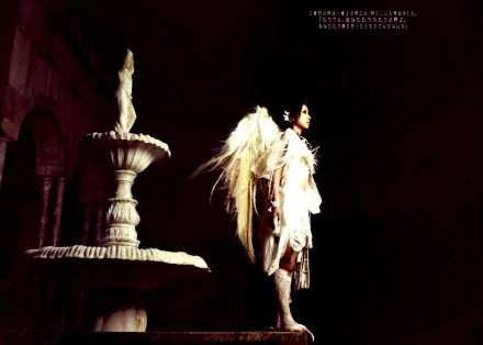 HD PC desktop wallpaper featuring Mika Nakashima with dramatic lighting, angelic wings, and a classic stone fountain in a dark, moody setting, emphasizing music and artistry.