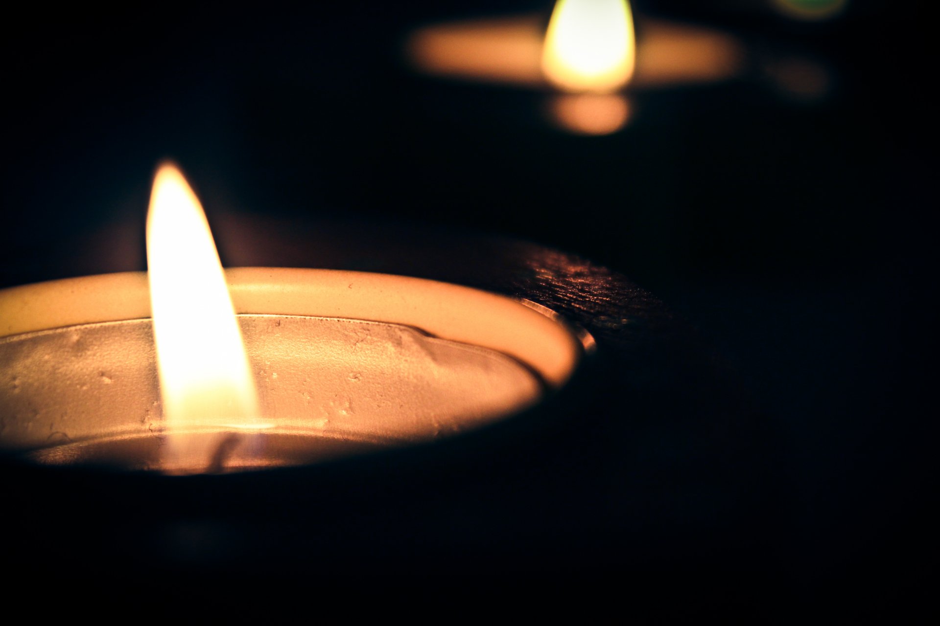 Close-up photography of a glowing candle flame in a dark setting, captured in stunning 4K Ultra HD quality as a PC desktop wallpaper and background.