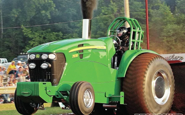 HD desktop wallpaper featuring a green John Deere vehicle, showcasing a powerful tractor in action with large rear tires and a driver inside.