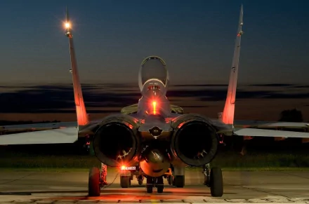 A Mikoyan MiG-29 jet on the tarmac, illuminated by sunset, showcases its sleek design and powerful engines in this HD desktop wallpaper.