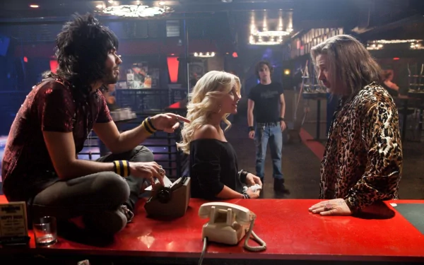 Rock of Ages movie HD desktop wallpaper — dim rock-club bar scene: a blonde woman sits at a red counter between two men as they engage in a tense conversation.