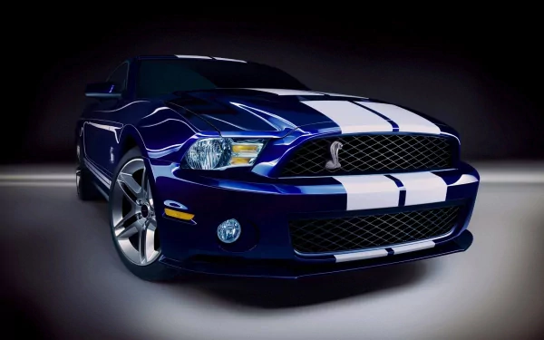 HD desktop wallpaper featuring a blue Ford Mustang Shelby GT500 with white racing stripes on a dark background.