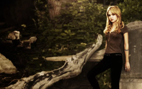 HD PC desktop wallpaper featuring celebrity Brittany Robertson standing outdoors against a natural, wooded background with a fallen tree and greenery.