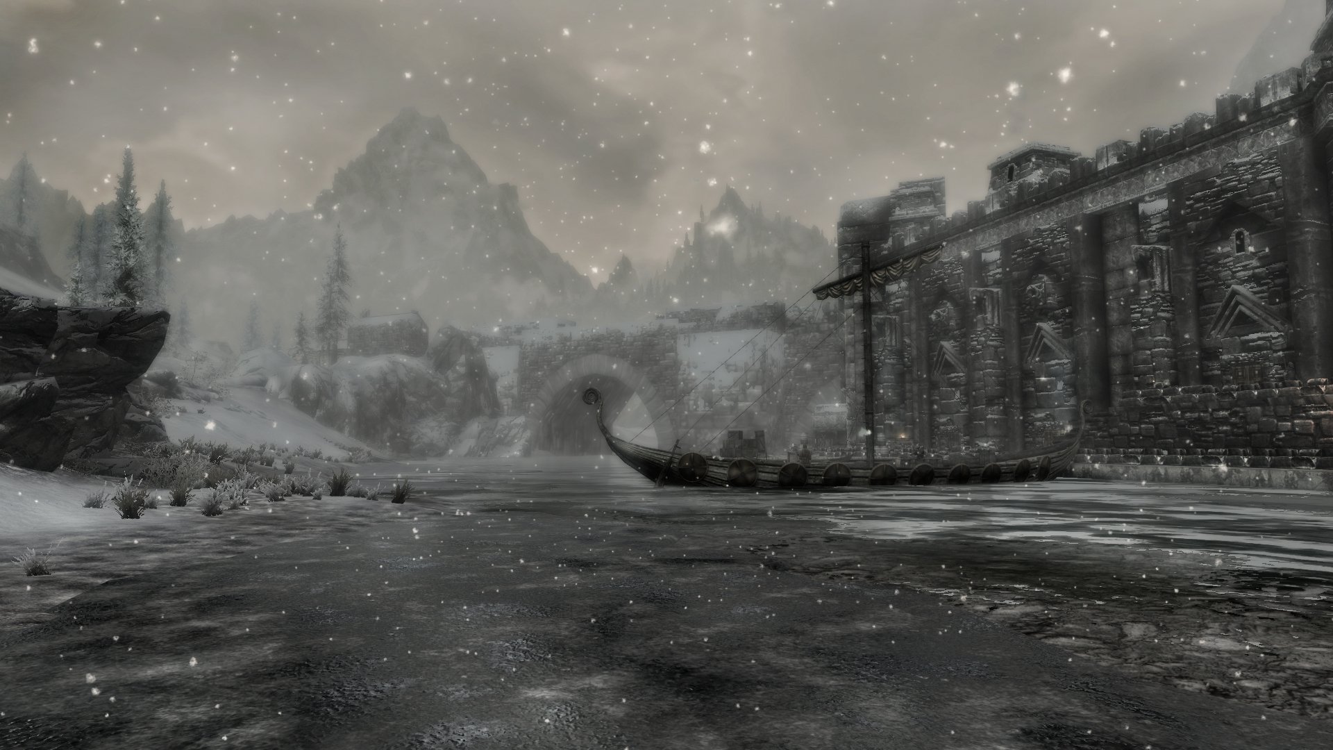 A serene winter scene in The Elder Scrolls V: Skyrim, featuring a snow-covered river, a stone building, and majestic mountains in the background, all captured in stunning HD detail.