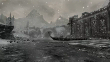 A serene winter scene in The Elder Scrolls V: Skyrim, featuring a snow-covered river, a stone building, and majestic mountains in the background, all captured in stunning HD detail.