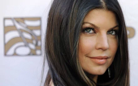 Close-up of Fergie, showcasing her long dark hair and striking features, set against a soft background. This HD PC desktop wallpaper captures her vibrant presence in music.