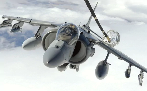HD military desktop wallpaper featuring a close-up of a McDonnell Douglas AV-8B Harrier II jet flying above the clouds.