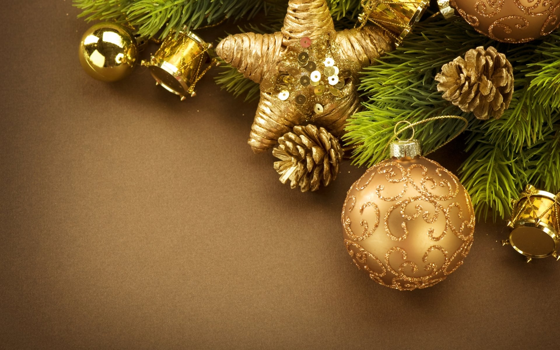 HD desktop wallpaper featuring Christmas ornaments, pinecones, and evergreen branches in gold and green hues, capturing a festive holiday atmosphere.