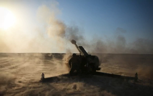 HD military desktop wallpaper showing artillery firing in a dusty, open battlefield under a clear sky.