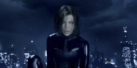 HD PC desktop wallpaper featuring a dark, moody scene from the movie Underworld: Awakening with a focused female character in a black outfit against a cityscape at night.