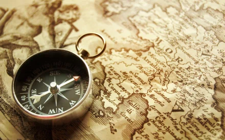 HD desktop wallpaper featuring a man-made compass resting on an antique map, evoking exploration and navigation themes.