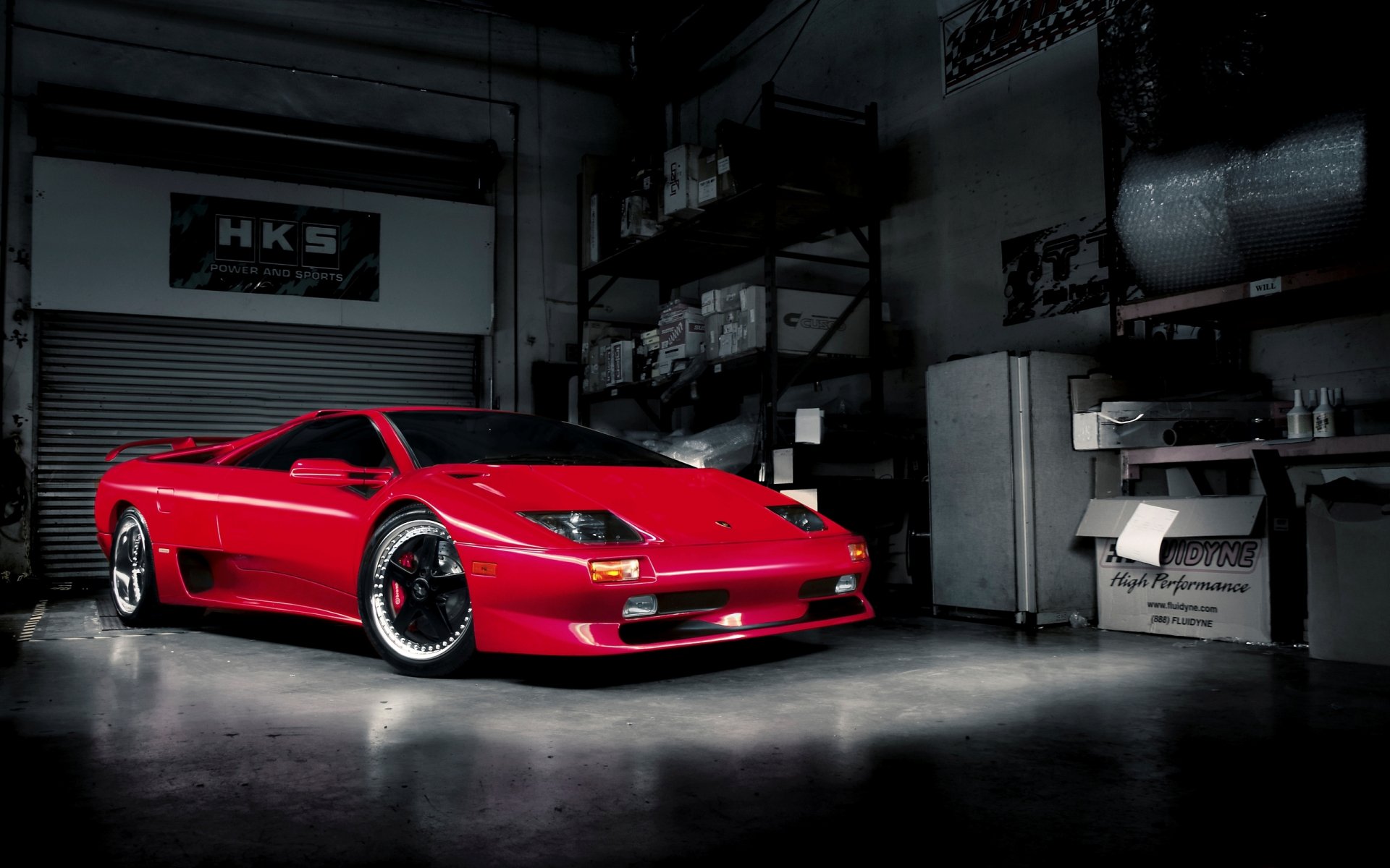 Red Lamborghini Diablo vehicle parked in a dim garage under dramatic lighting — 2K Quad HD PC desktop wallpaper/background.