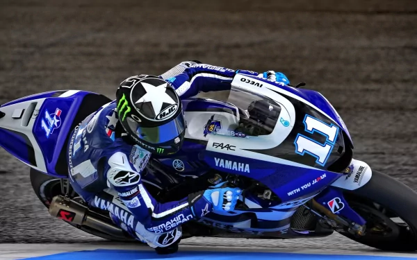 MotoGP rider on a blue and white Yamaha bike, captured in action on the track. An HD desktop wallpaper and background featuring an intense moment in sports racing.