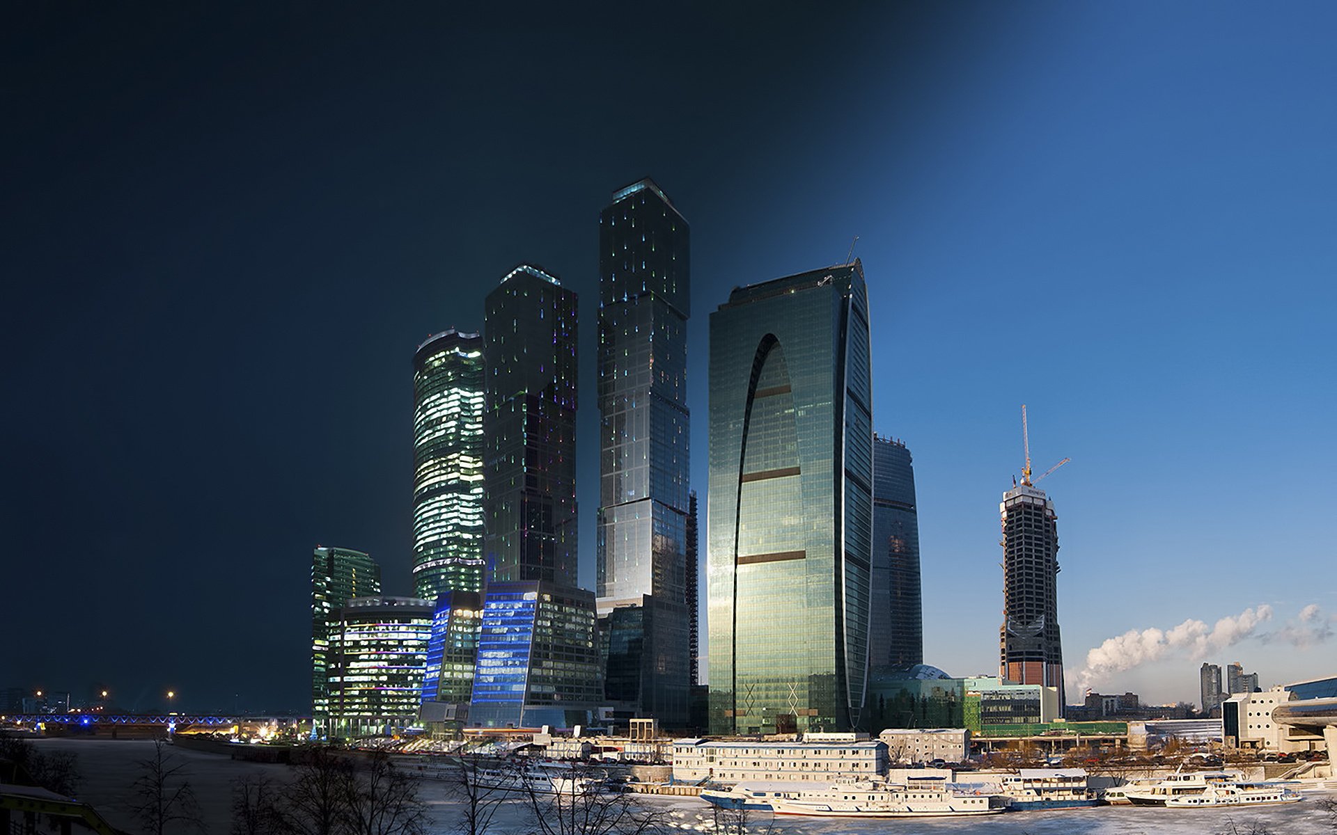 HD PC wallpaper of Moscow, Russia — man-made skyline of the Moscow International Business Center with glass skyscrapers glowing above a snowy riverbank at dusk.