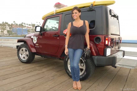 Woman standing beside a red SUV on a wooden pier, with palm trees and a coastal backdrop, featured as an HD PC desktop wallpaper in the Girls & Cars theme.