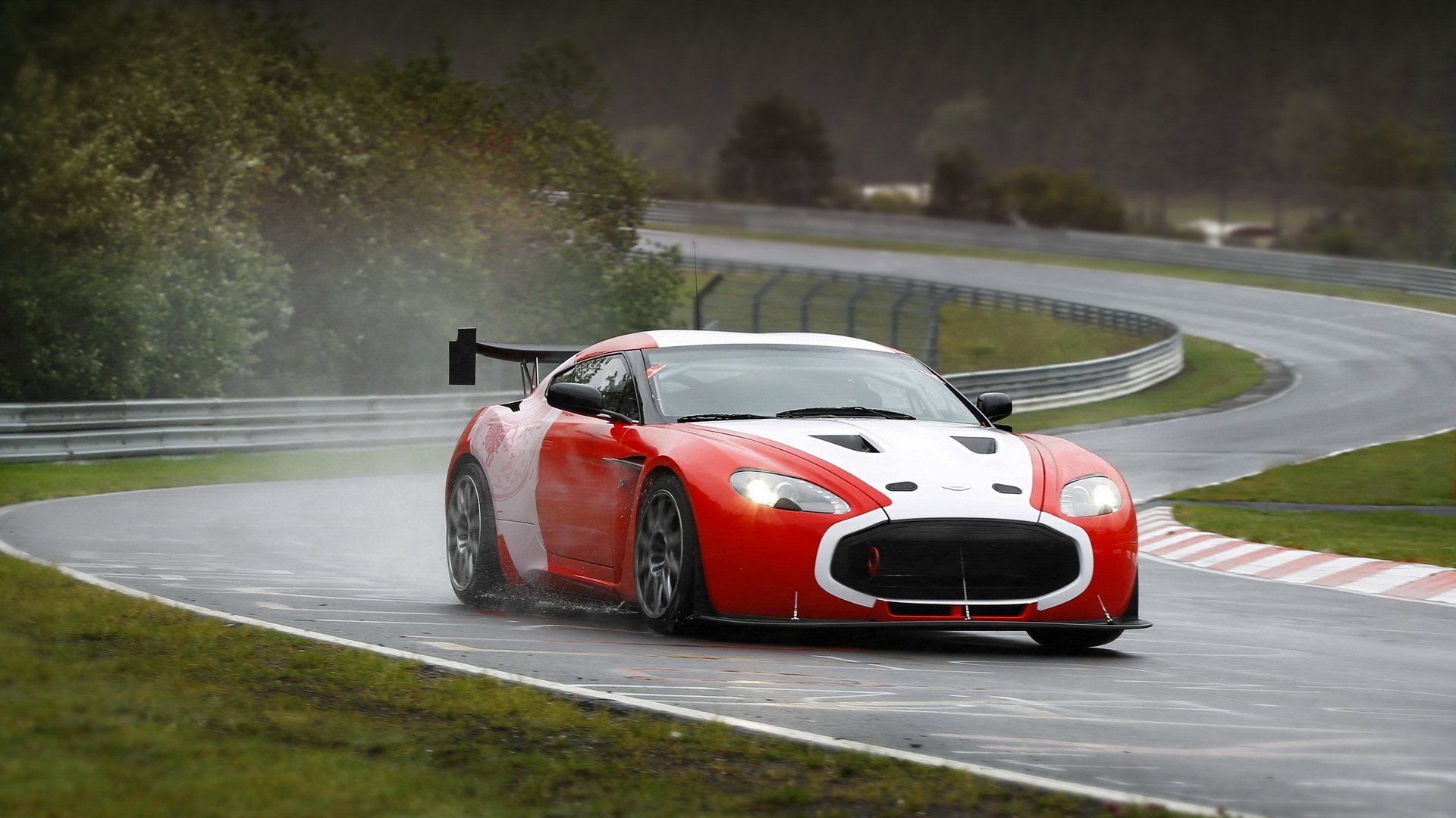 HD PC desktop wallpaper/background: red-and-white sports car (vehicle) skidding through rain on a curving racetrack, spray trailing behind.