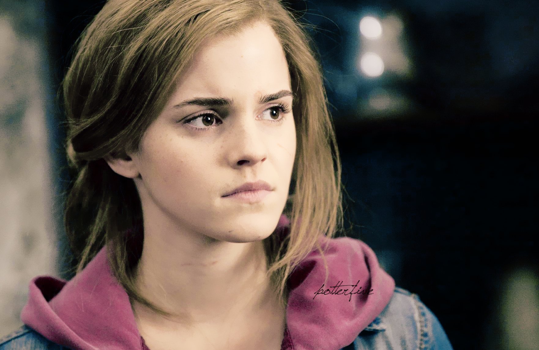 HD desktop wallpaper featuring a close-up of celebrity Emma Watson with a contemplative expression against a softly blurred background.