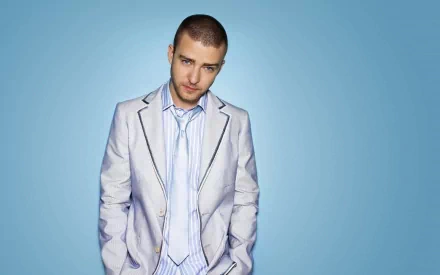 HD PC desktop wallpaper showing a male pop musician in a light suit and tie posing against a soft blue background.