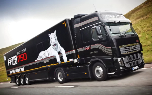 A Volvo FH16 750 truck in striking black livery with a tiger design, captured in motion against a scenic backdrop, serves as a dynamic HD desktop wallpaper.