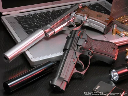 HD PC desktop wallpaper: man-made scene of Beretta pistols, suppressor, ammunition and a laptop keyboard.