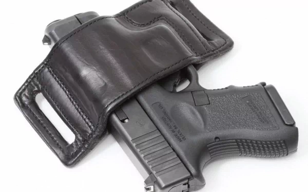 HD desktop wallpaper featuring a Glock pistol partly concealed in a black leather holster, with a white background highlighting the man-made firearm.