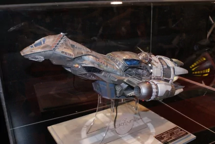 Detailed model of the Serenity spaceship from TV show Firefly on a display stand, dramatic lighting and dark background — 4K Ultra HD PC desktop wallpaper/background.