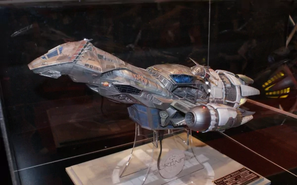 Detailed model of the Serenity spaceship from TV show Firefly on a display stand, dramatic lighting and dark background — 4K Ultra HD PC desktop wallpaper/background.