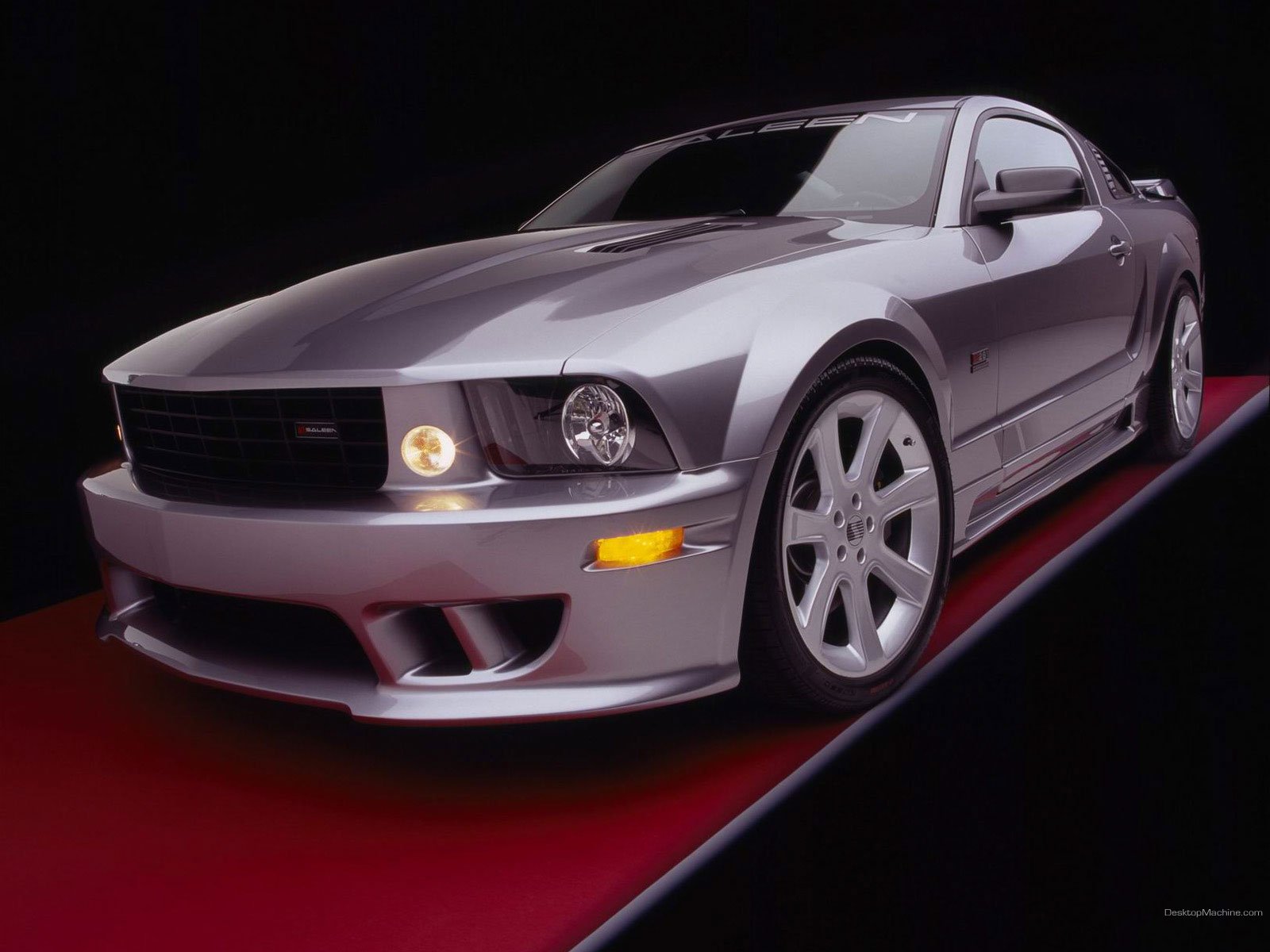 HD PC desktop wallpaper featuring a sleek silver Ford Mustang with illuminated headlights on a glossy black and red reflective surface.