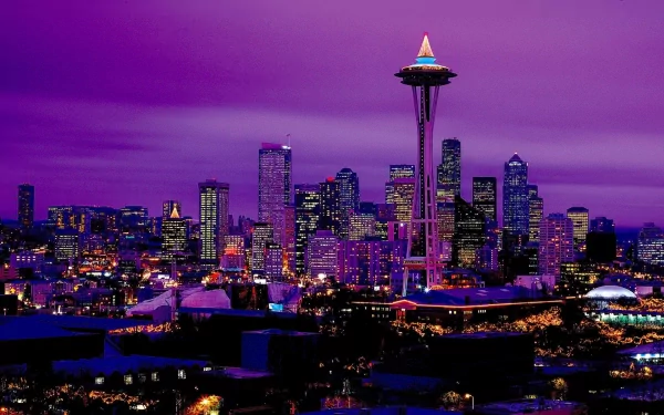 Nighttime view of Seattle’s city skyline with the illuminated Space Needle standing tall under a vibrant purple sky, captured in high definition as a desktop wallpaper.