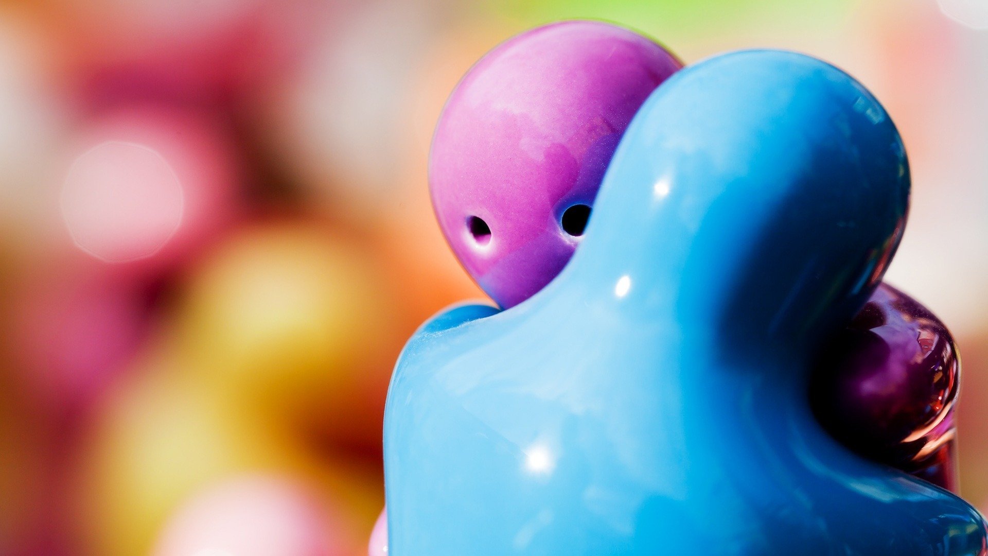 A vibrant HD desktop wallpaper featuring a blue and pink artistic representation of two figures in a warm embrace, symbolizing love against a colorful, abstract background.