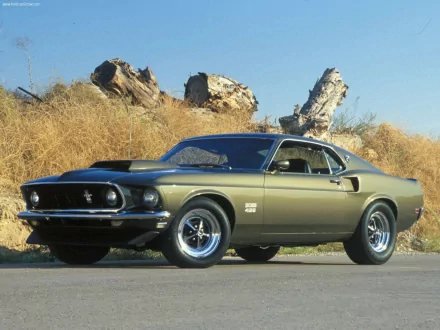 HD PC desktop wallpaper featuring a classic Ford vehicle parked on a roadside with dry grass and rock formations in the background.