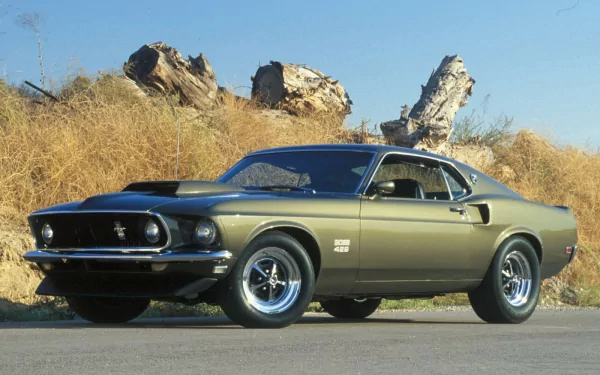 HD PC desktop wallpaper featuring a classic Ford vehicle parked on a roadside with dry grass and rock formations in the background.