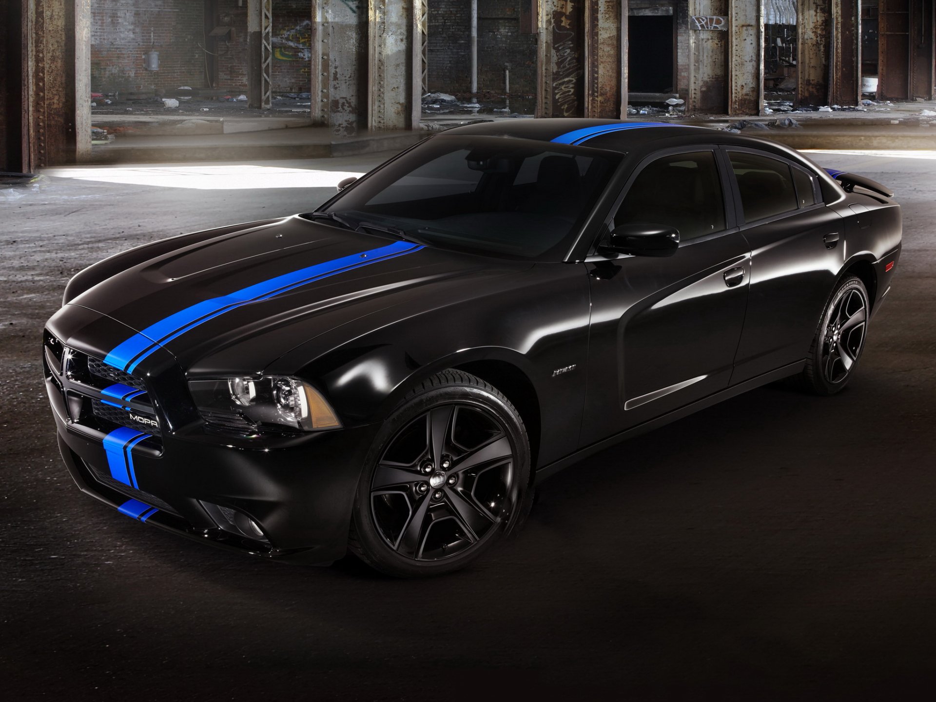 HD desktop wallpaper featuring a sleek black Dodge vehicle with bold blue racing stripes, showcased in an industrial setting.