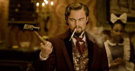 HD PC desktop wallpaper featuring a scene from the movie Django Unchained with Leonardo DiCaprio's character holding a hammer and smoking a cigarette.