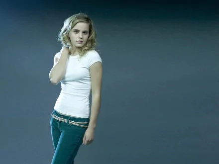 HD desktop wallpaper featuring celebrity Emma Watson standing against a neutral background, wearing a white t-shirt and dark pants.