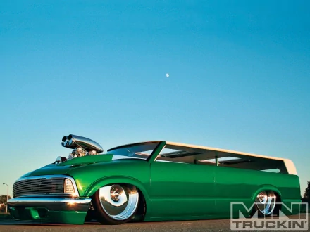 HD PC desktop wallpaper featuring a sleek green custom truck with a prominent engine blower under a clear blue sky.