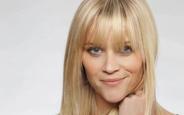 HD PC desktop wallpaper of a smiling blonde celebrity with bangs and blue eyes against a soft gray background