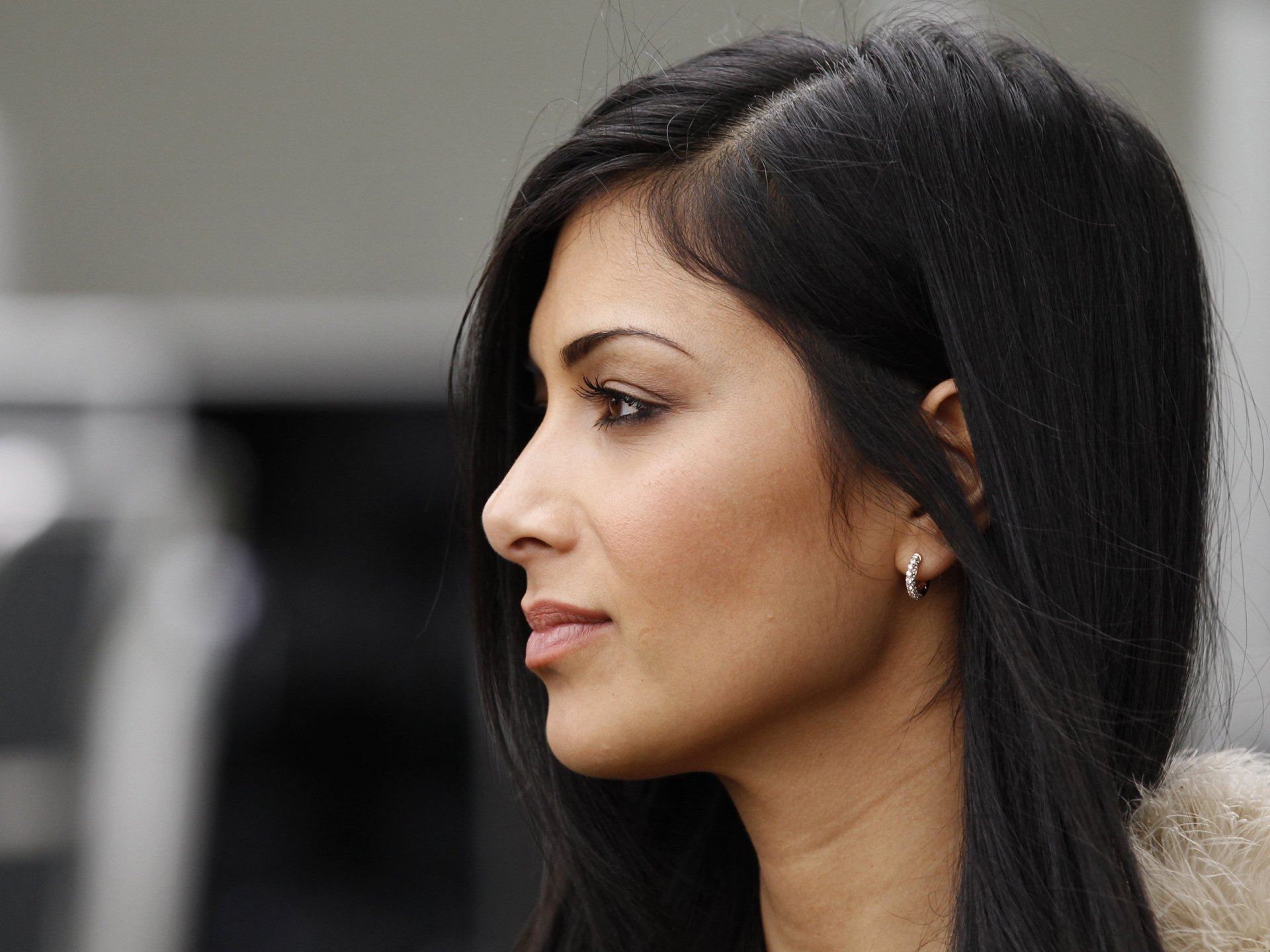 HD PC desktop wallpaper featuring a close-up side profile of Nicole Scherzinger with a focused expression, highlighting her sleek black hair and silver hoop earrings.